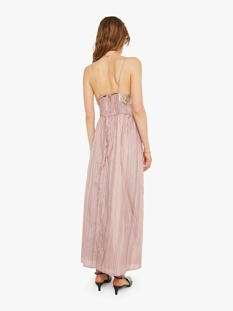 Back  view of a woman formal midi dress in mauve, and features a V-neck, thin spaghetti straps, a fitted bodice with coin embellishments, and a loose, flowy skirt that hits at the calf.