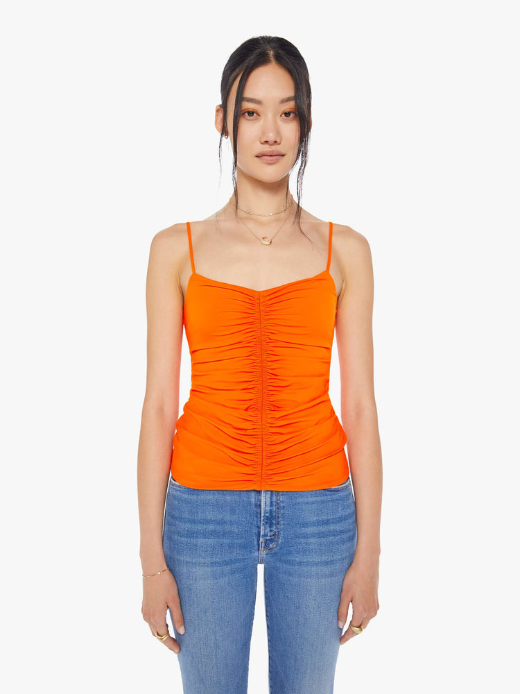 Front view of a neon orange sleeveless top with a shallow V-neck, thin spaghetti straps, a gathered seam down the front and a narrow fit.