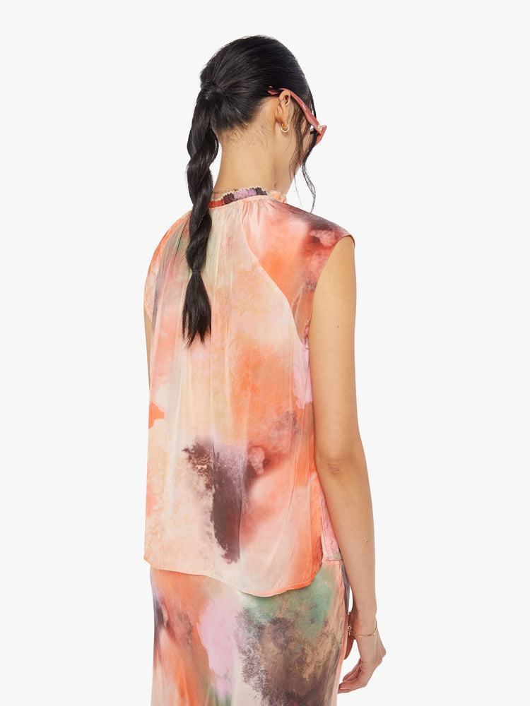 Back view of a watercolor inspired top with a V-neck with a ruffled collar that ties, super-short sleeves and a loose, flowy fit.