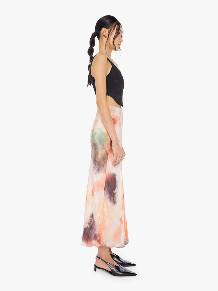 Side view of a woman water color inspired maxi skirt with a super high rise and an A-line fit with an ankle-length hem.