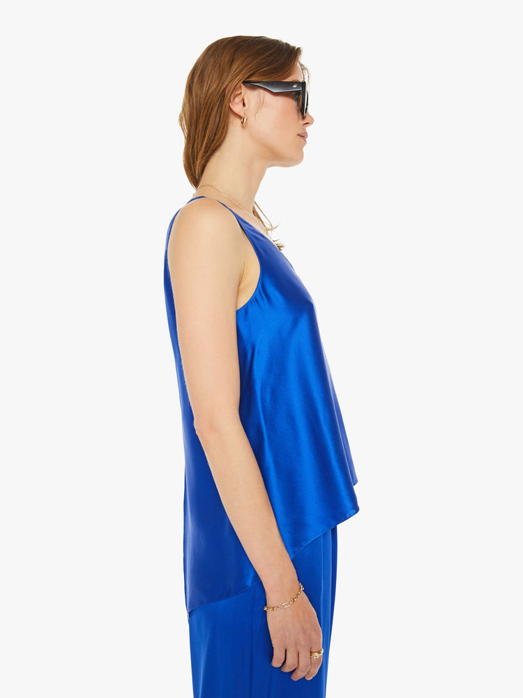 Side view of a woman in a royal blue scoop tank with thick straps and a loose, flowy fit.