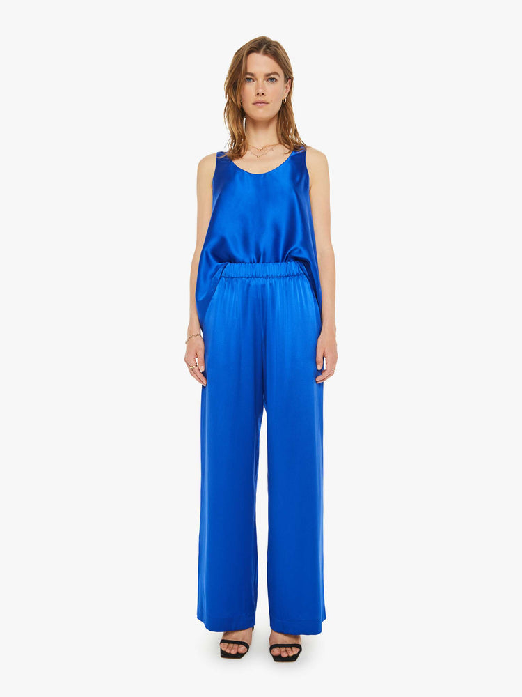 Front view of a woman wide leg royal blue trousers with an elastic waist, side slit pockets and a loose, flowy fit.