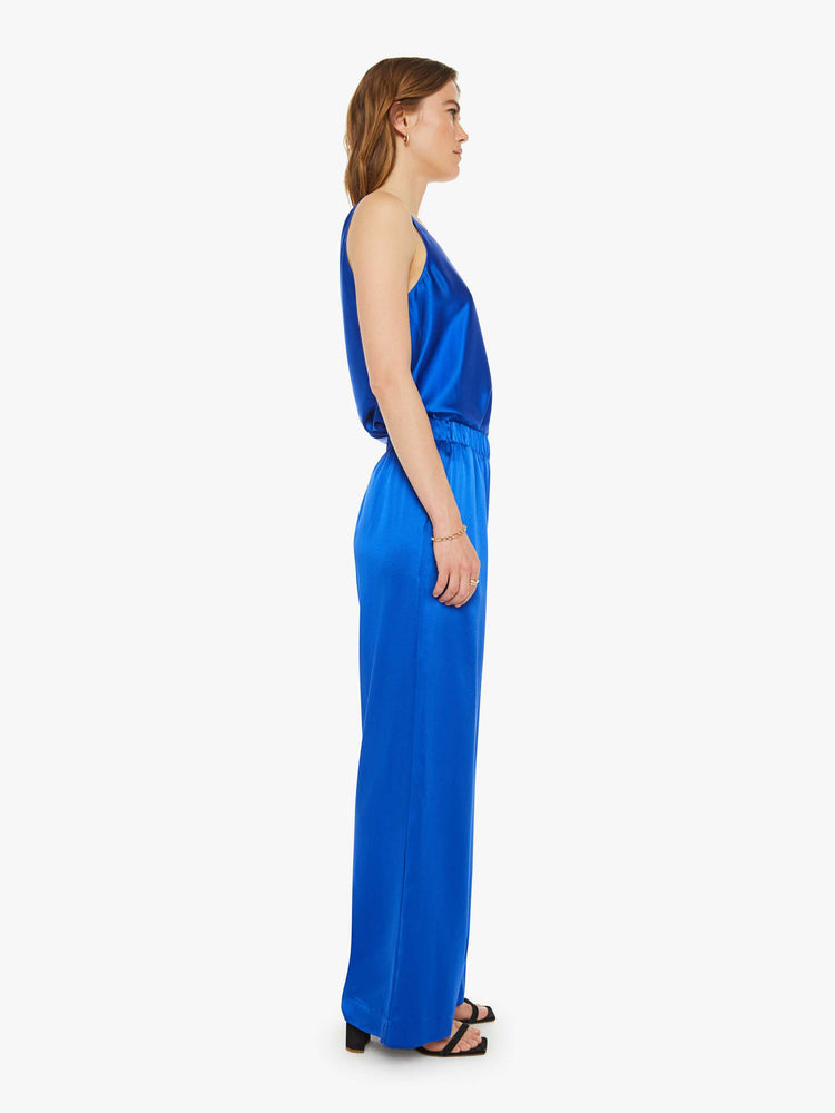 Side view of a woman wide leg royal blue trousers with an elastic waist, side slit pockets and a loose, flowy fit.