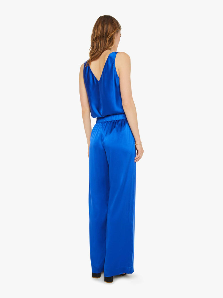 Back view of a woman wide leg royal blue trousers with an elastic waist, side slit pockets and a loose, flowy fit.