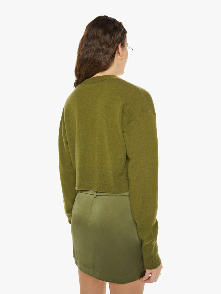 Back view of a woman in a green deep V-neck, drop shoulders, ribbed hems and a slightly cropped fit.