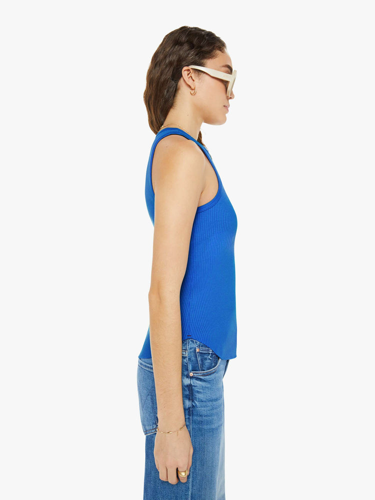 Side view of a woman in a blue tank top with a scoop neck, slim fit and hip-grazing hem.