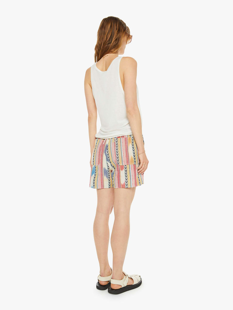 Back view of a woman in shorts have a mid rise, drawstring elastic waist, deep patch pockets, a loose fit and a long inseam that hits just above the knee.