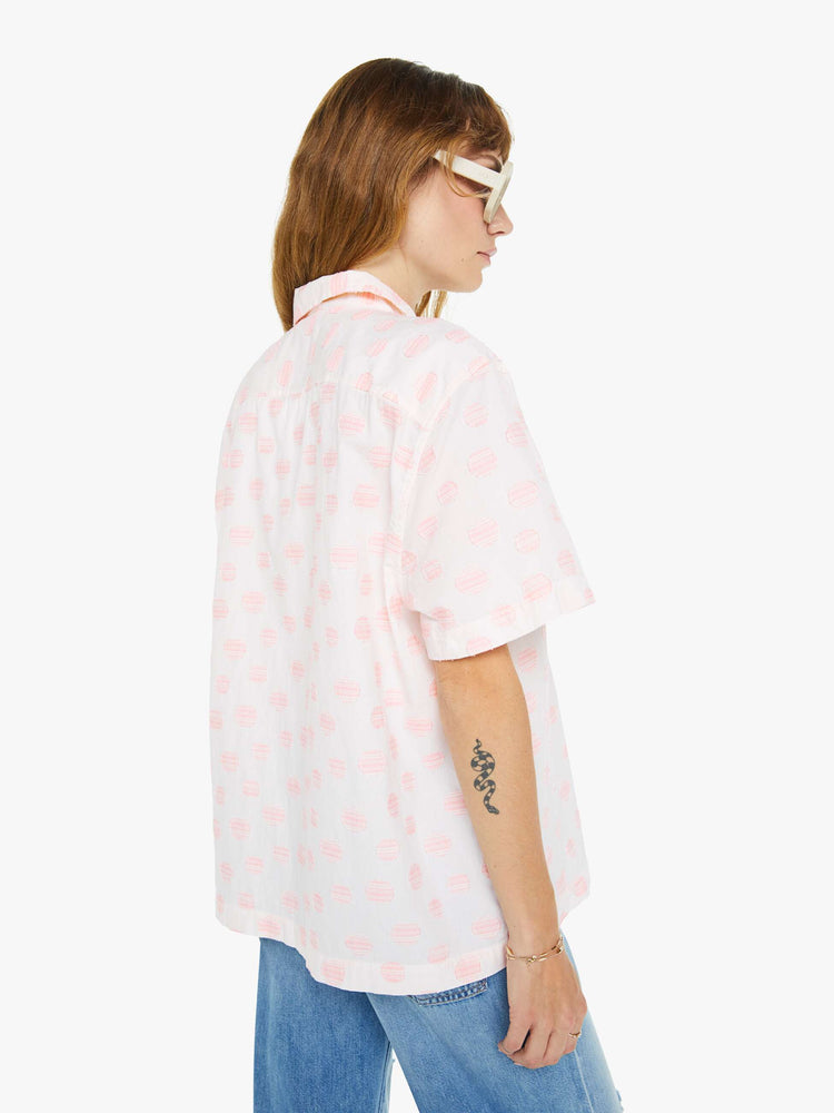 Back view of a woman wearing an white oversized short sleeve button down shirt with pink polka dots.