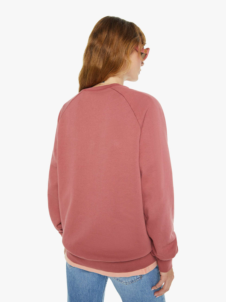 Back view of a woman in a faded brick sweatshirt with a relaxed shape with raglan sleeves and is decorated with a white anchor graphic on the chest.