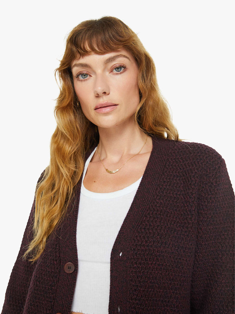 Close up view of a woman in dark maroon vneck cardigan.