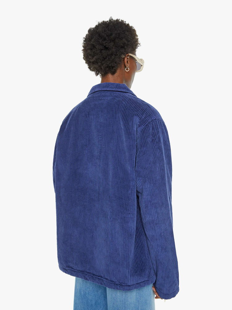 WOMAN back view in an ocean blue with brown buttons collared button-up jacket.