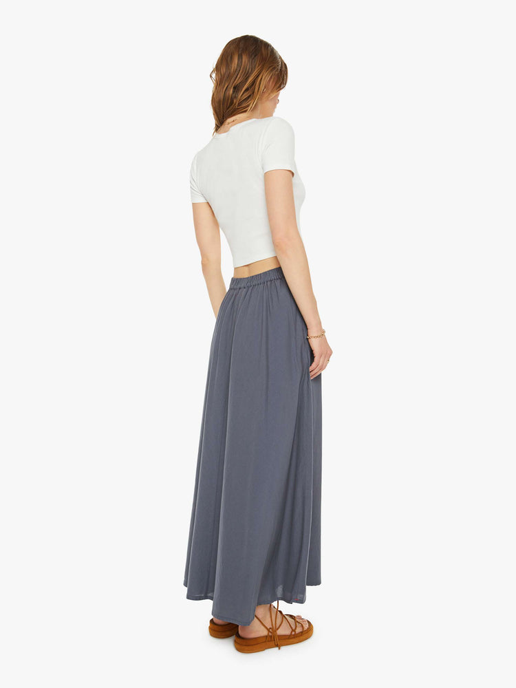 Back view of a woman in an ash grey skirt with an elastic waistband and a loose, flowy fit.