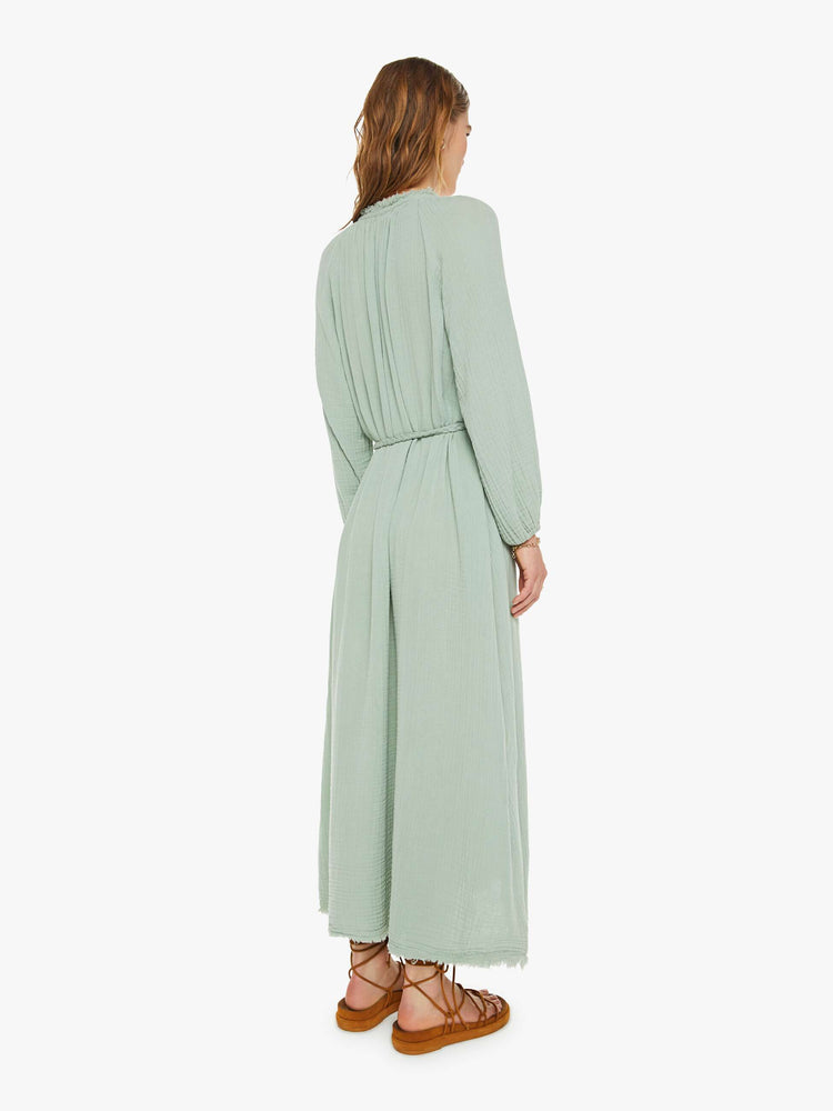 Back view of a woman maxi dress designed with a V-neck, long balloon sleeves, buttons down the front, a tied waist and ankle-grazing hem in a soft green gray.