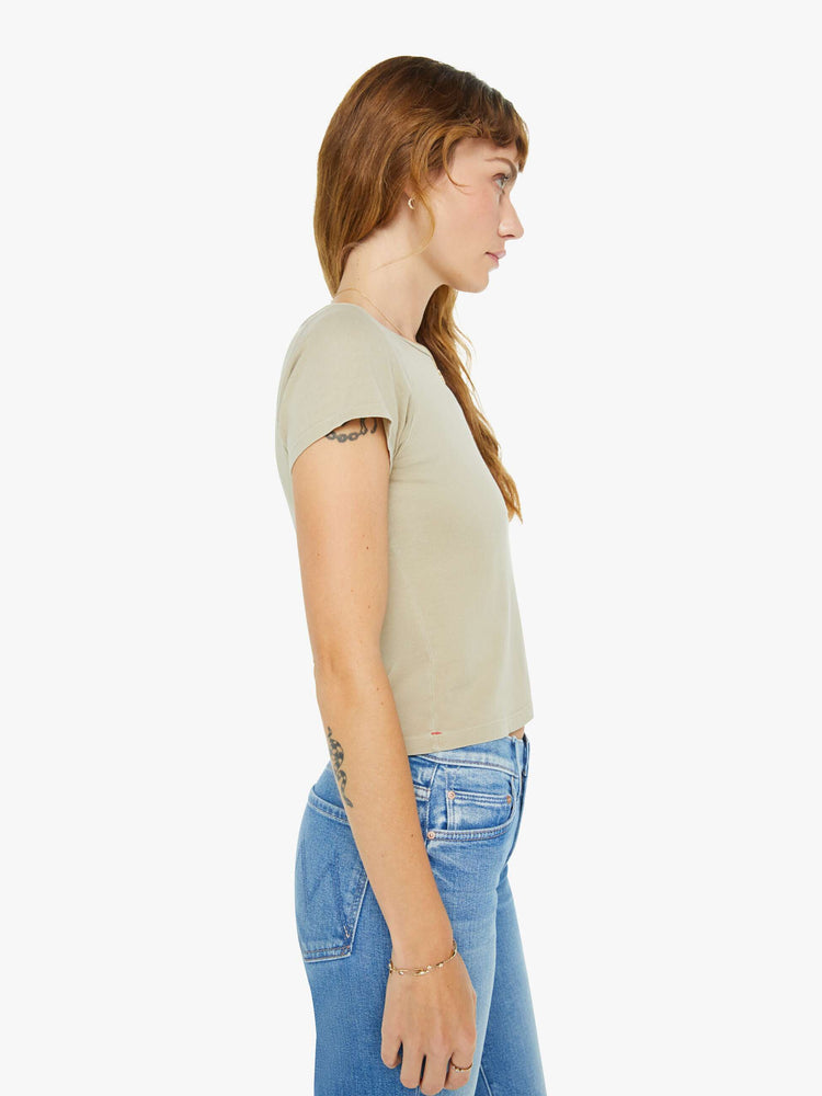 Side view of a woman in taupe tee with a cropped hem and shrunken fit.