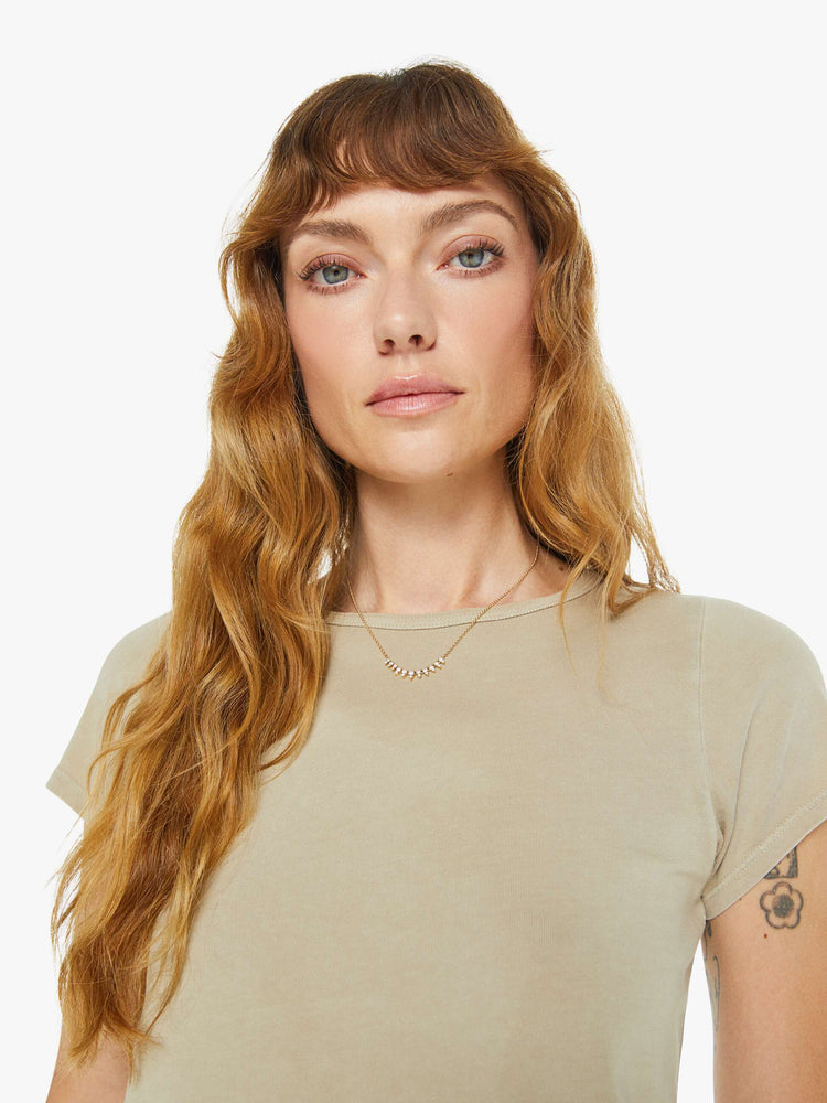 Close up view of a woman in taupe tee with a cropped hem and shrunken fit.