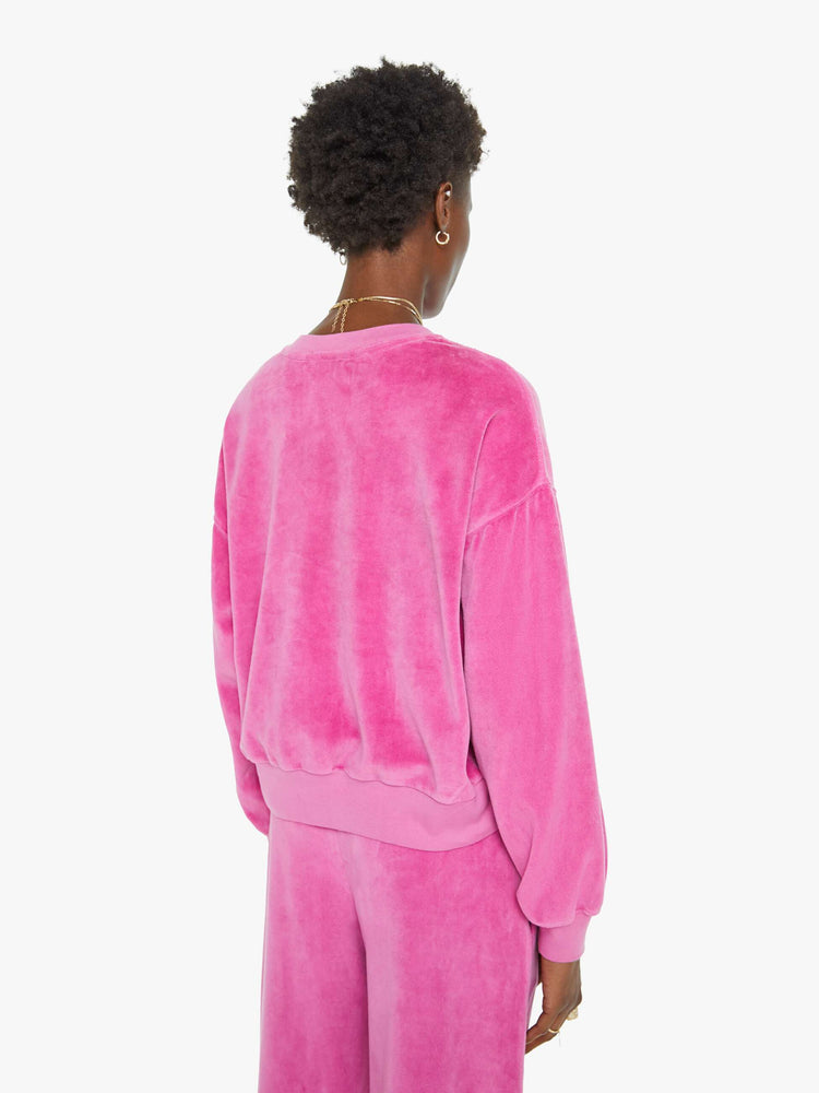 Back view of a woman in a pink velour sweatshirt features a crew neck, drop shoulders, ribbed hems and a slightly cropped fit.