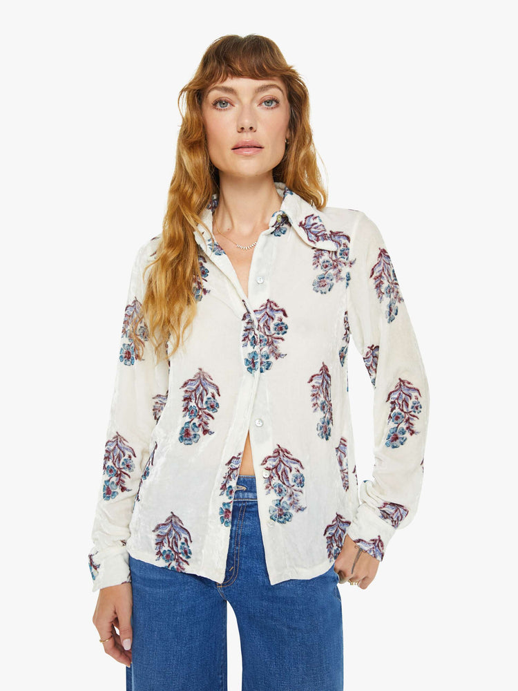 Front view of a woman blouse in off-white velvet with a cool-toned floral print, and features a collared neck, buttons down the front and long sleeves.