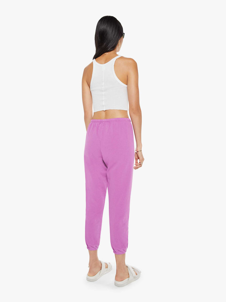 Back view of a woman in pink sweatpants are designed with a drawstring waistband, elastic hems, a loose, wide leg and the brand's logo in red at the hip.