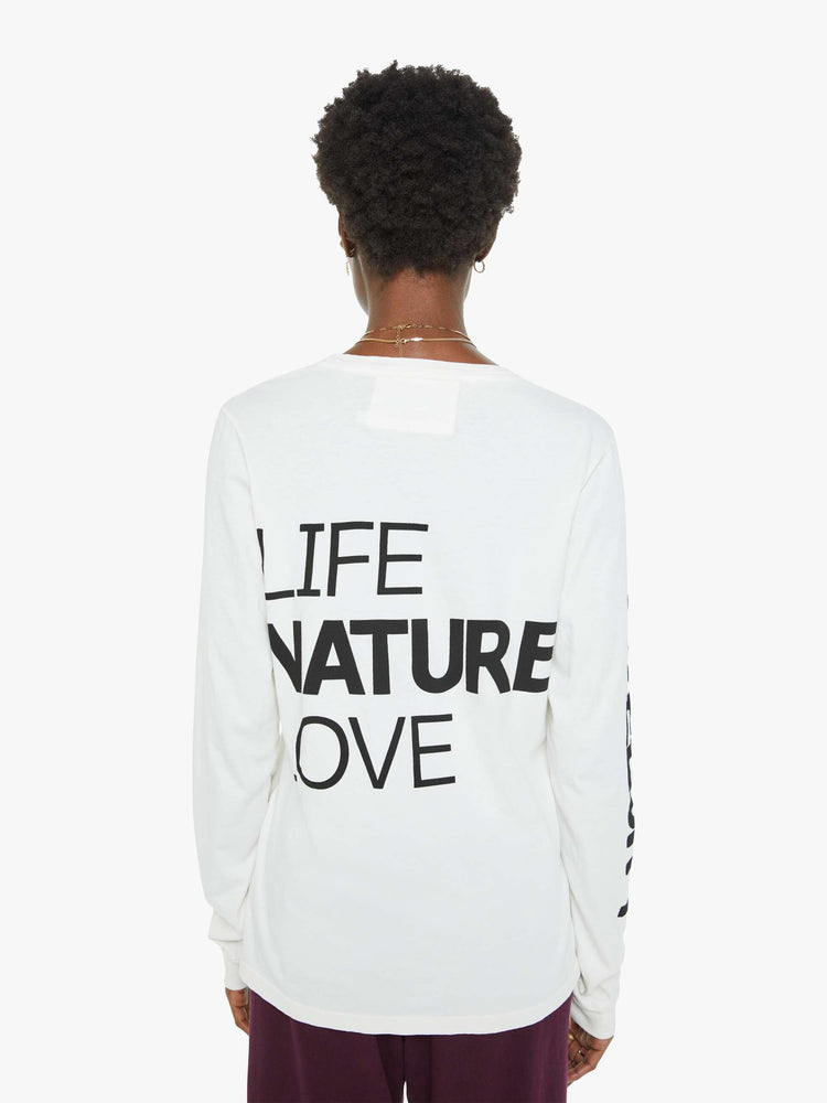 Back view of a woman long sleeve tee designed with ribbed hems, an oversized fit, a white bird on the chest and a text graphic on the back.