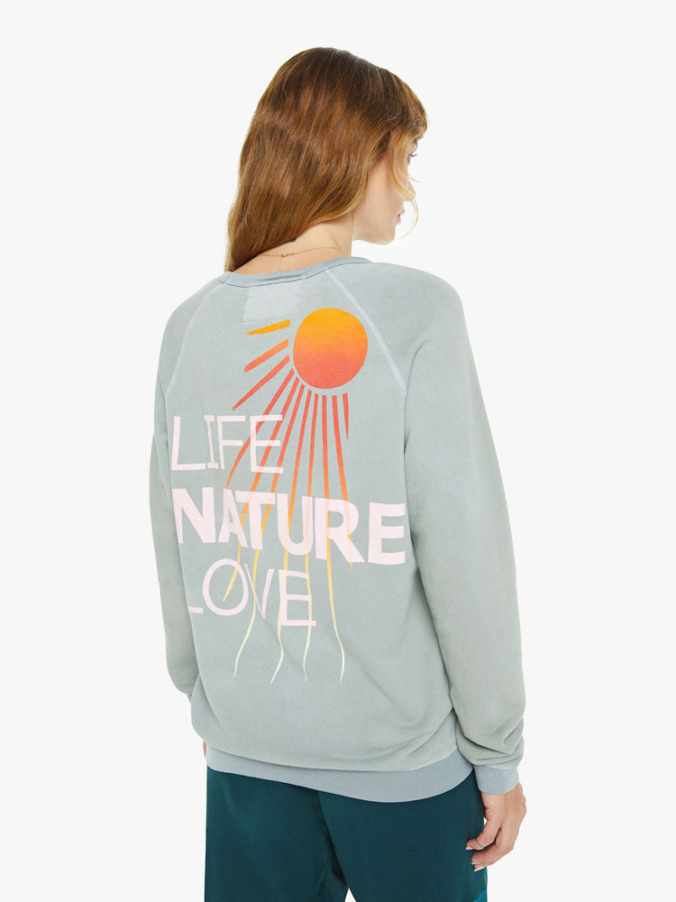 Back view of a woman in a in a light sky blue raglan sweatshirt designed with ribbed hems and an oversized fit.