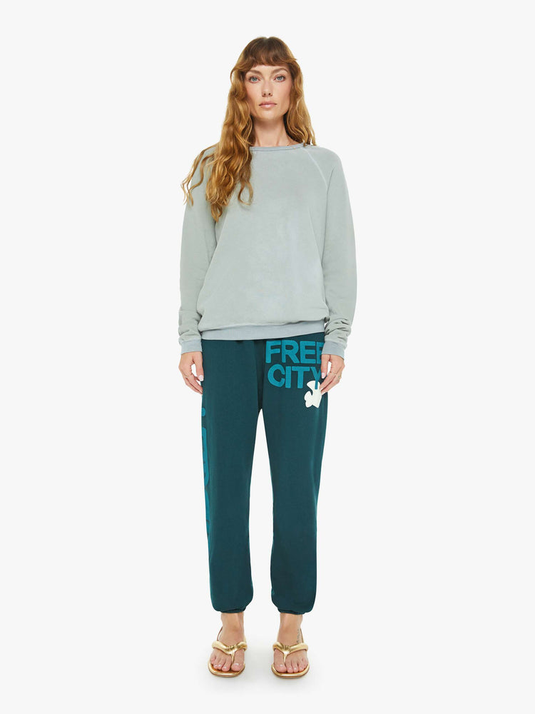 Full body view of a woman in a in a light sky blue raglan sweatshirt designed with ribbed hems and an oversized fit.