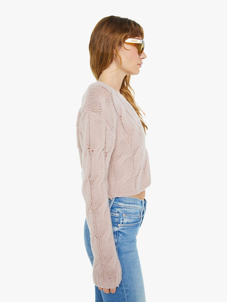 Side view of a woman in deep V-neck, drop shoulders, ribbed hems and a slightly cropped fit cardigan in a dusty pink.