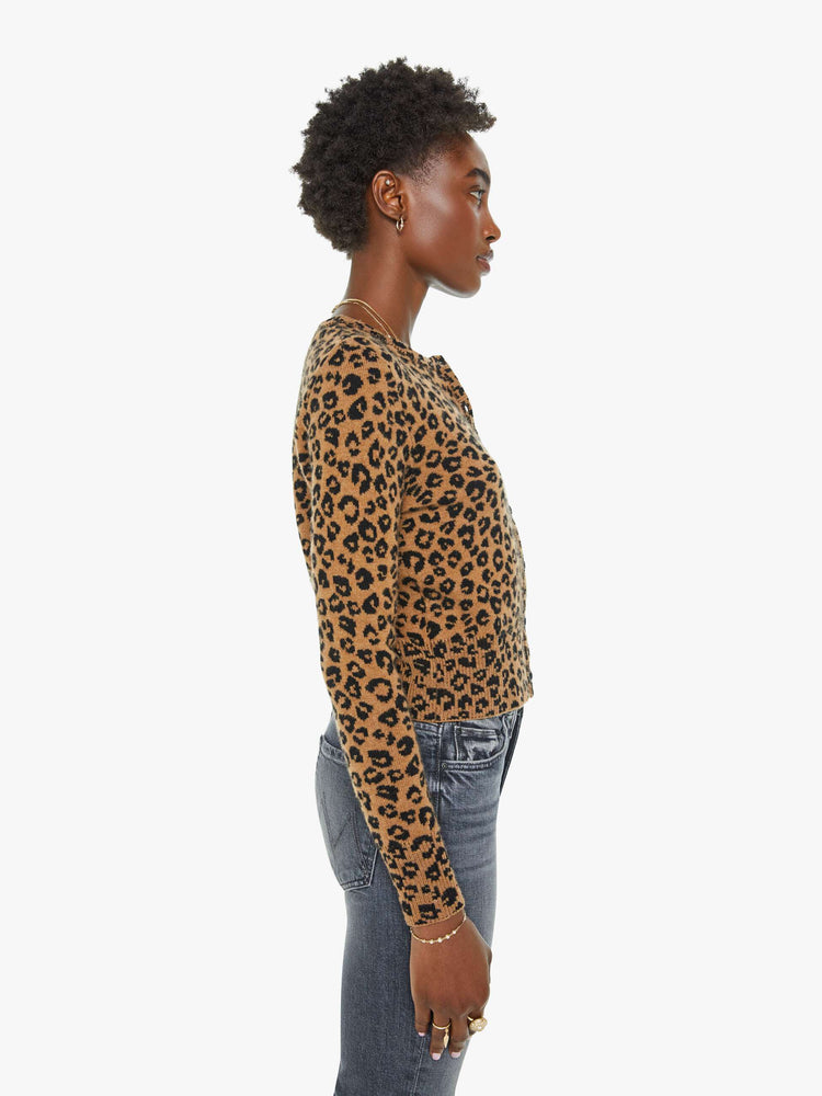 Side view of a woman in a leopard print cardigan.