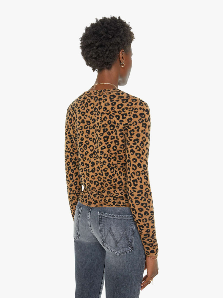 Back view of a woman in a leopard print cardigan.