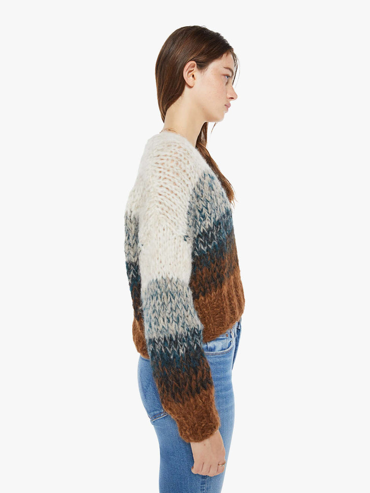 Side view of a woman sweater is hand knit from a soft alpaca blend in a brown, grey and cream ombre design.