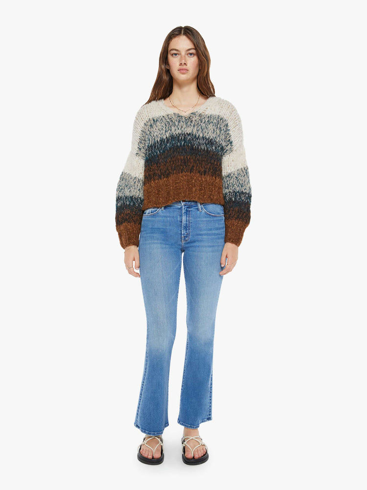 Full body view of a woman sweater is hand knit from a soft alpaca blend in a brown, grey and cream ombre design.