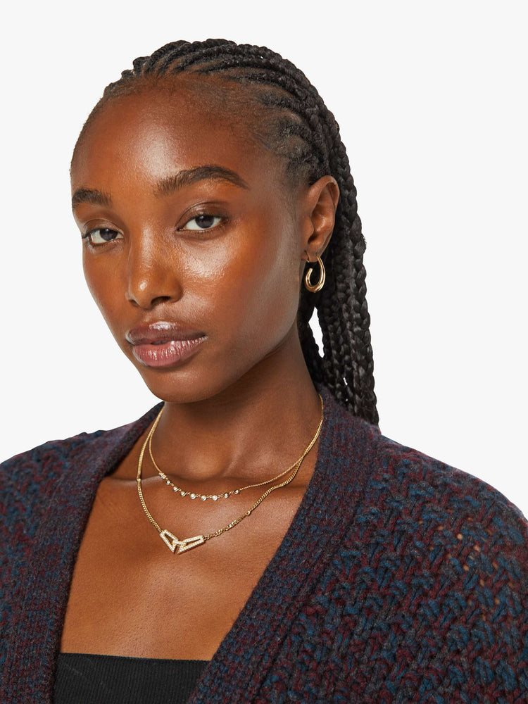 Close up view of a woman in rich red cardigan with a deep V-neck, drop shoulders, ribbed hems and a cropped, slouchy fit. 