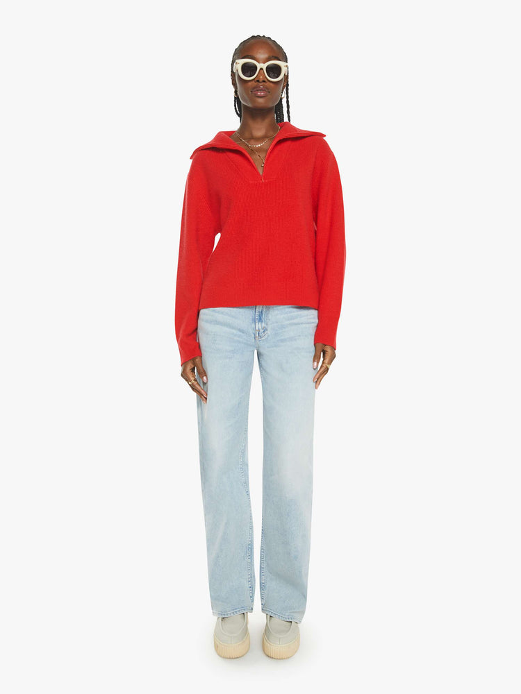 WOMAN Full body view of a woman in a red sweater with a V-neck that zips, drop shoulders and a loose fit.