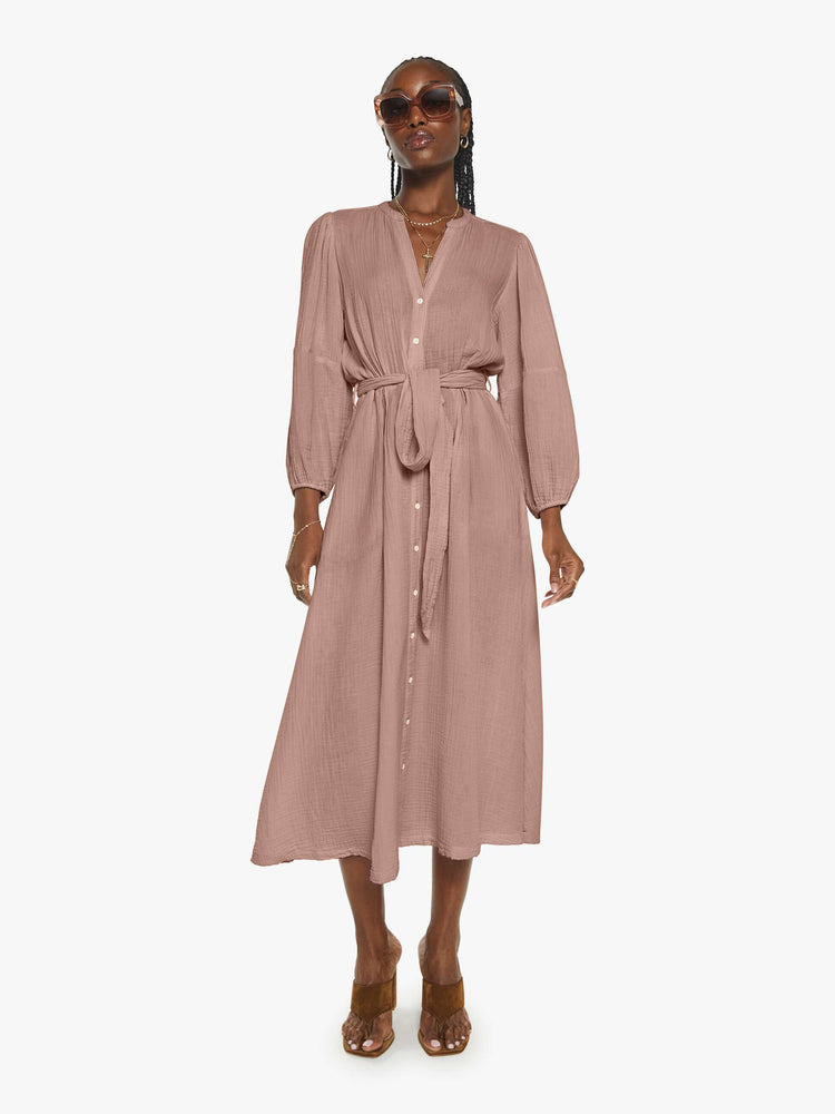 Front view of a woman in a dusty rose vneck button down the front and loose dress.