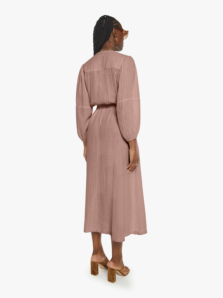 Back view of a woman in a dusty rose vneck button down the front and loose dress.