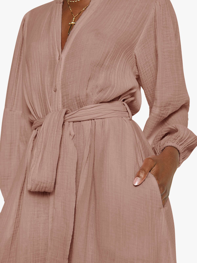 Close up view of a woman in a dusty rose vneck button down the front and loose dress.