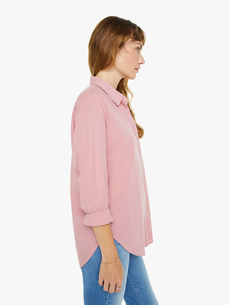 Side view of a woman in a rose pink button-down.