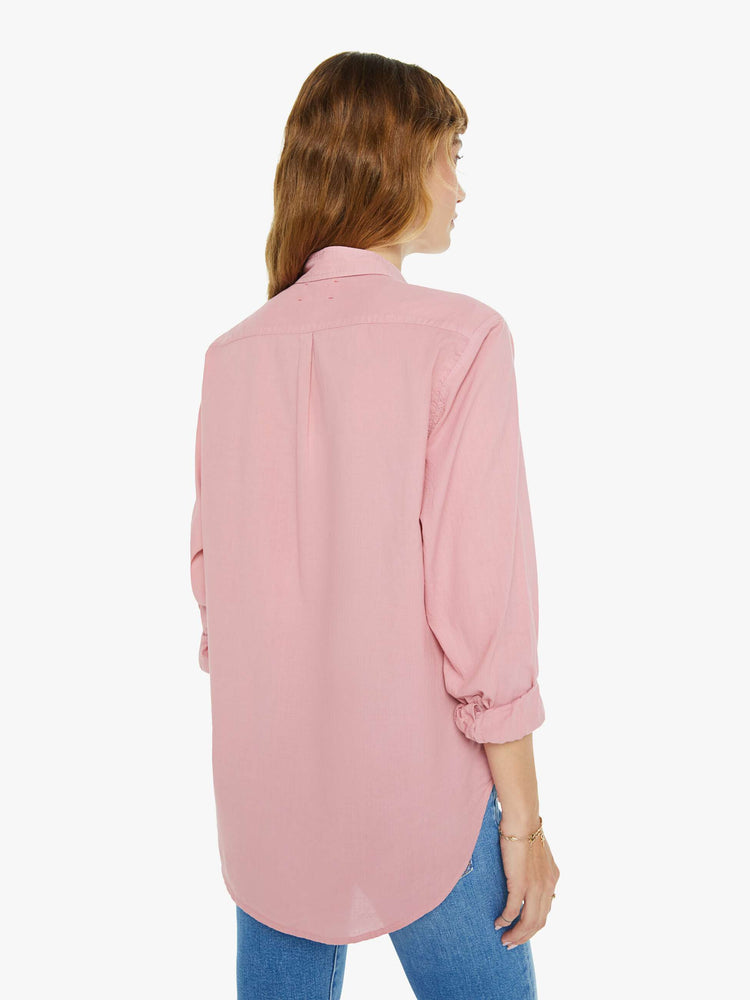 Back view of a woman in a rose pink button-down.