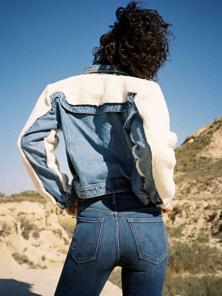 Editorial view of a woman in a dark blue skinny high rise with an ankle-length inseam and a clean hem.